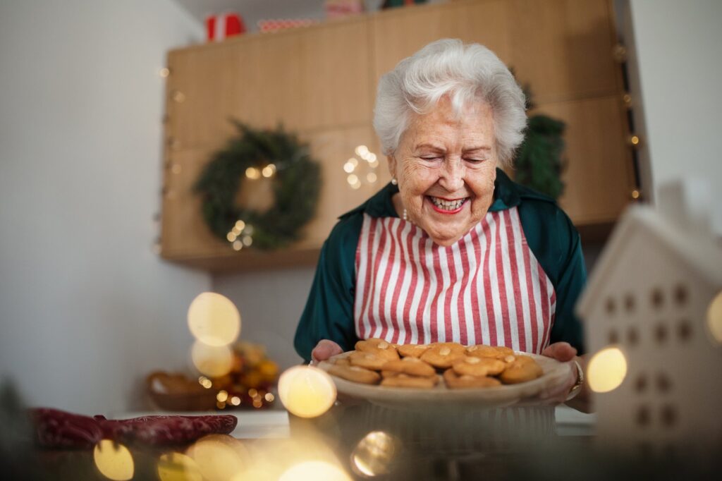 happy-senior-woman-baking-christmas-cakes-at-home